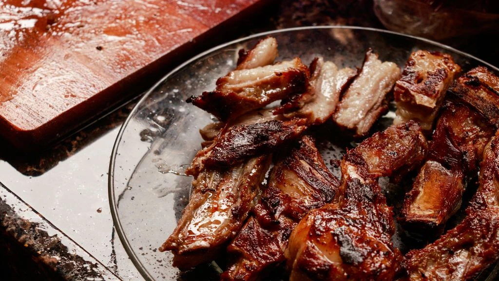 Charcoal tabletop grill with lemongrass pork skewers, herbs and lime